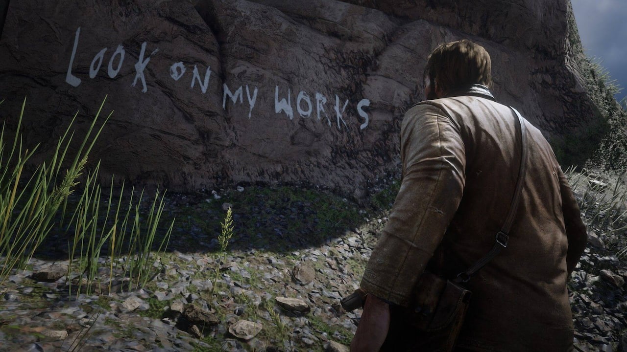 A screenshot of Red Dead Redemption 2 where Arthur Morgan looks at a rock with the words "Look on my works" painted across it by an in-game serial killer.
